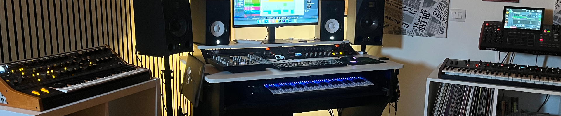 Lo studio di Sthage in provincia di Bergamo: scrivania di lavoro, pannelli in legno alle pareti e scaffale di dischi in vinile